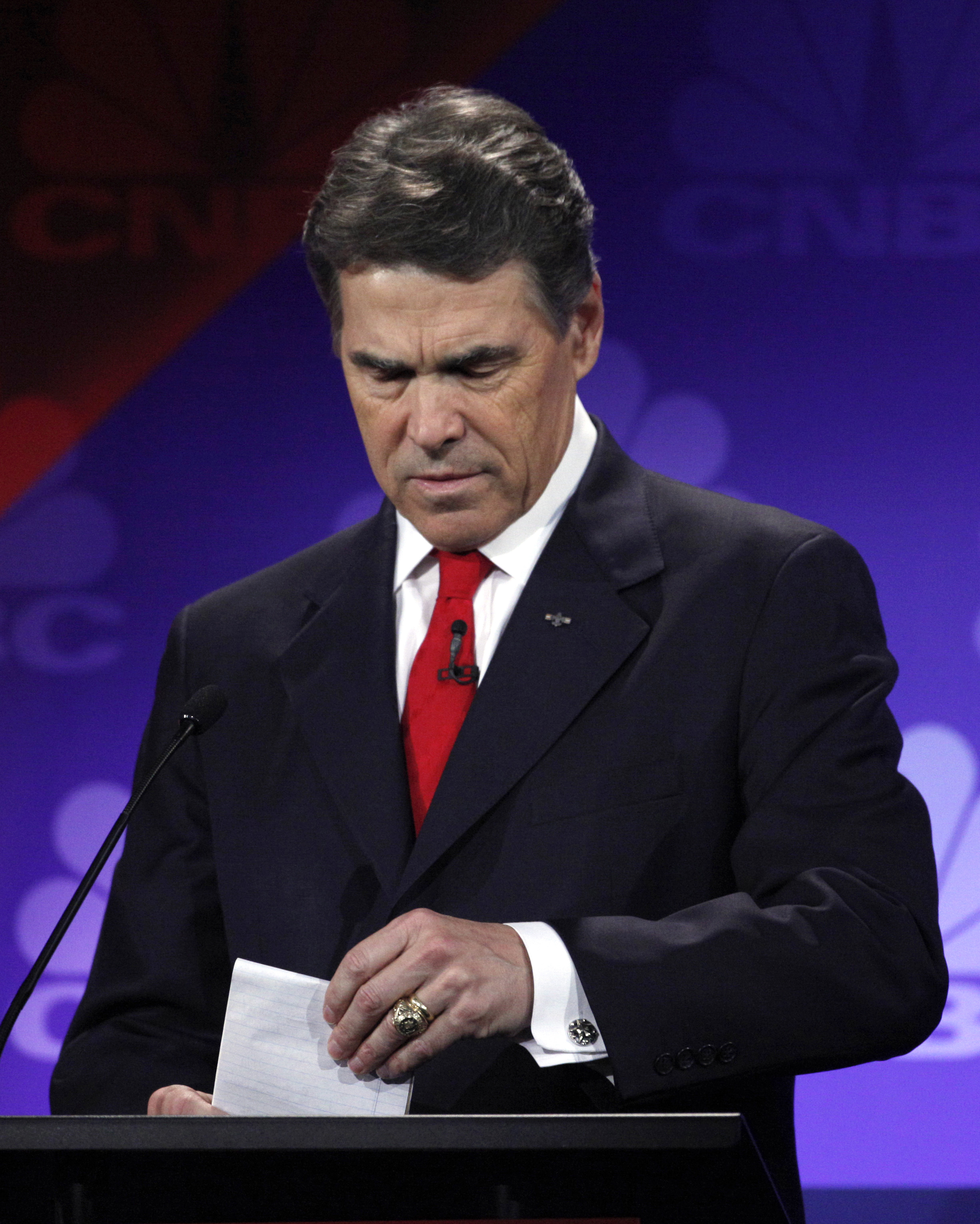 Republican presidential candidate Texas Gov. Rick Perry looks at his notes during a Republican Presidential Debate at Oakland University, Nov. 9 2011, in Auburn Hills, Mich.